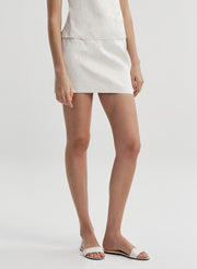 Woman wearing a cream colored mini skirt 