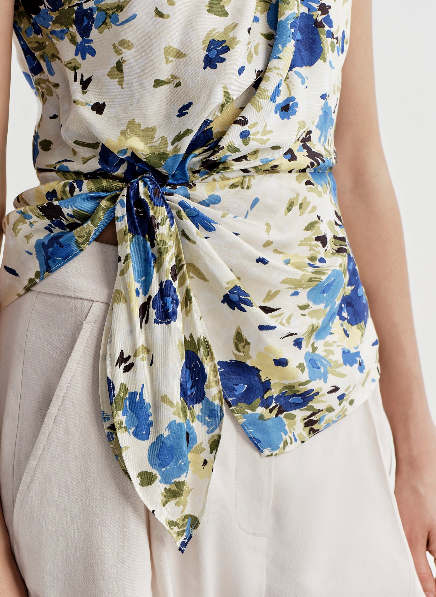 Floral patterned top with a tie detail on a plain background