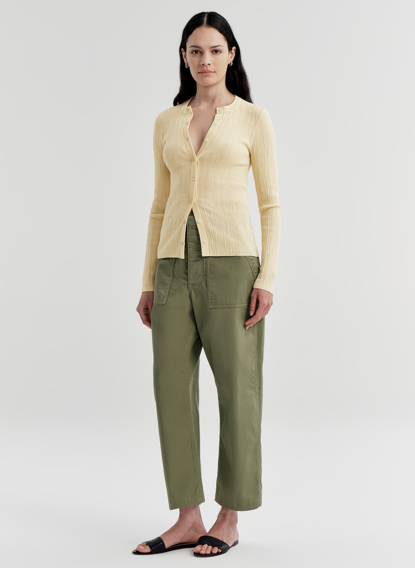 woman wearing butter yellow cardigan and green pants