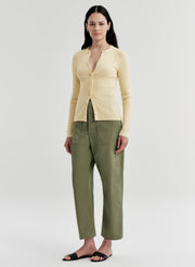 woman wearing butter yellow cardigan and green pants