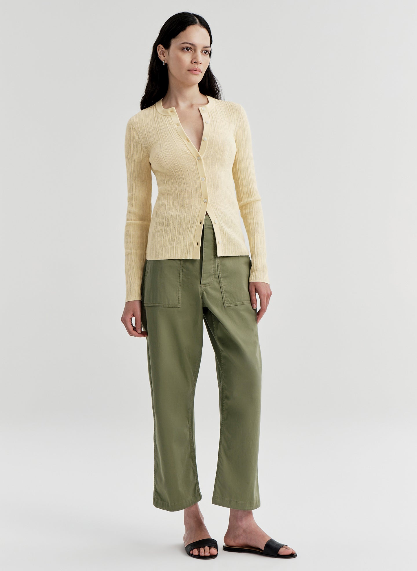 woman wearing yellow cardigan and green pants