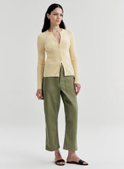 woman wearing yellow cardigan and green pants