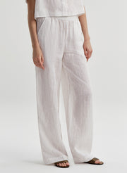 Close-up of a woman wearing ivory colored striped linen pants on a white background