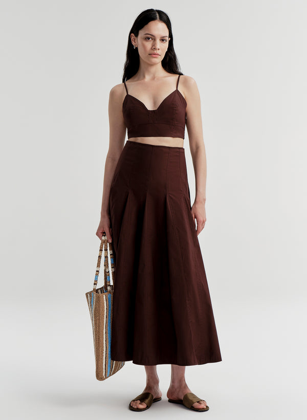 Woman wearing a brown skirt with a matching top on a white background