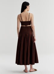 Woman wearing a brown skirt with a matching top on a white background