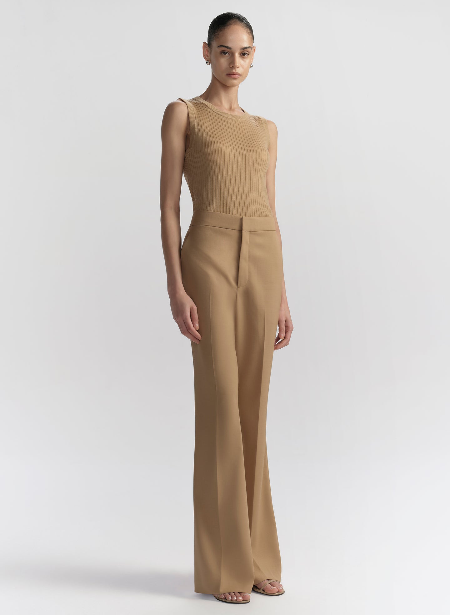 woman wearing tan sleeveless top and tan pants