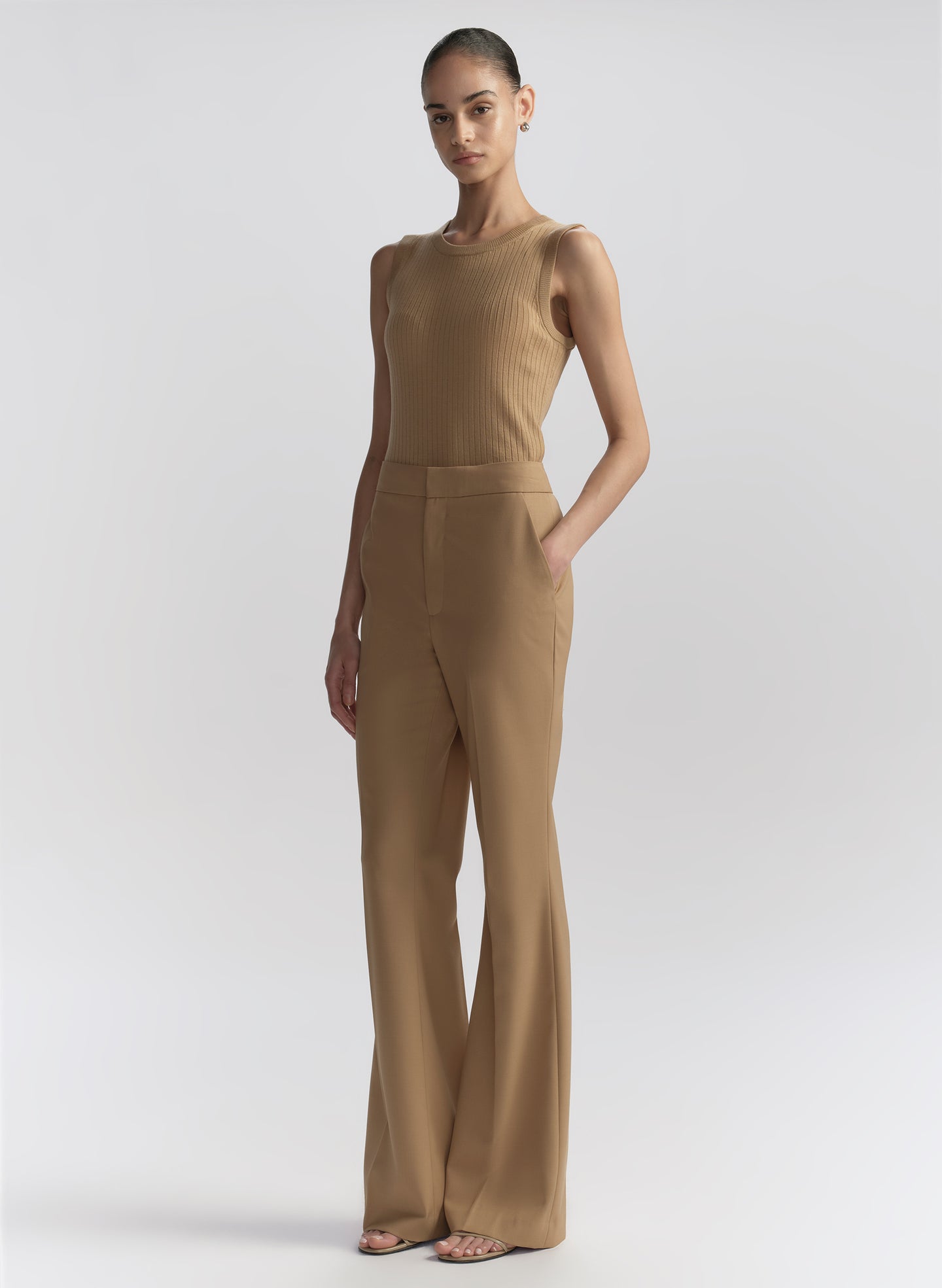 woman wearing tan sleeveless top and tan pants