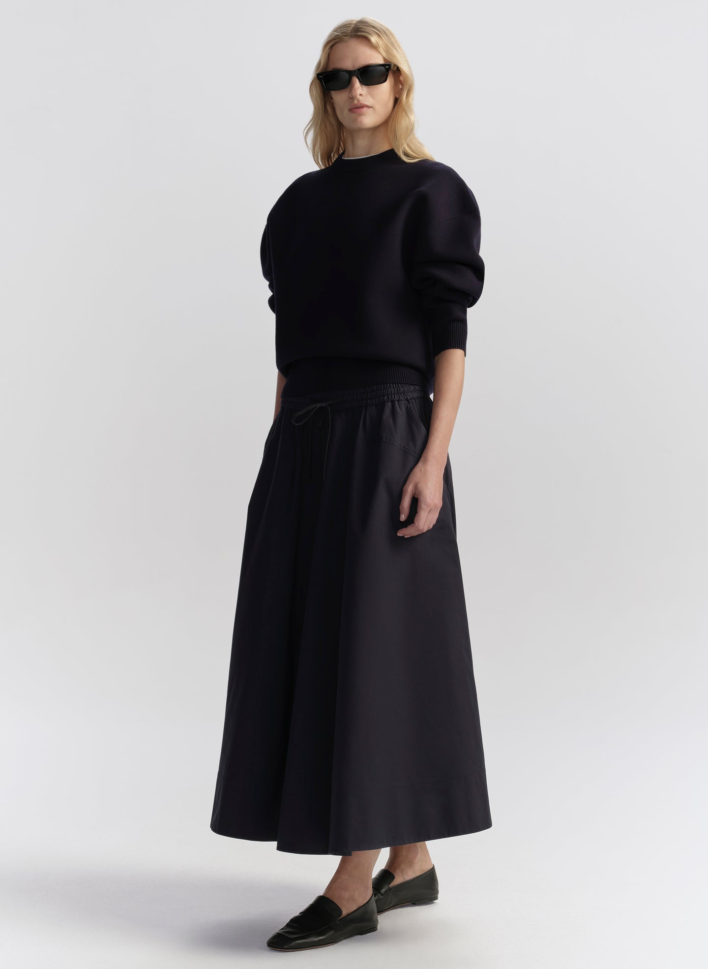 woman wearing navy blue top and navy blue midi skirt