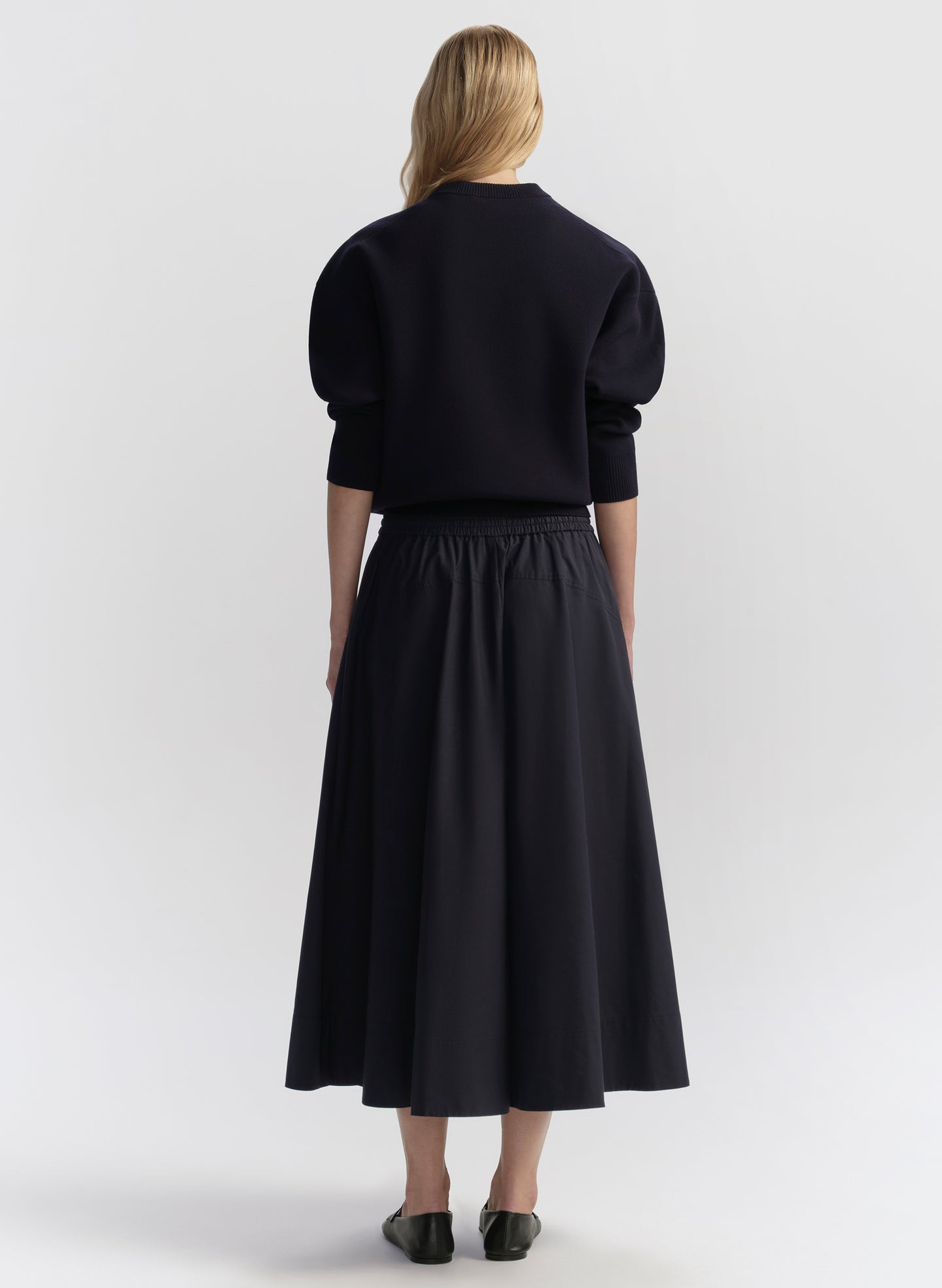 woman wearing navy blue top and navy blue midi skirt