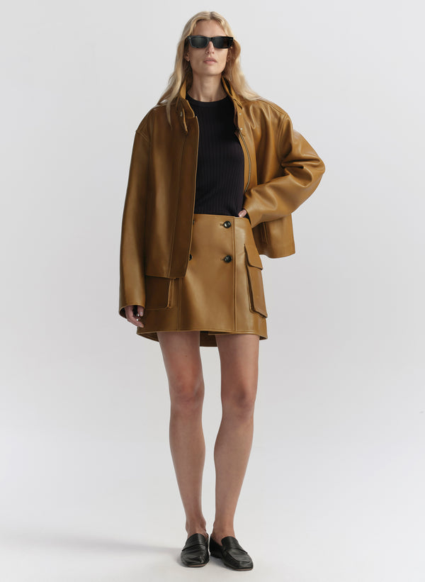 Woman wearing a brown coat and skirt with sunglasses on a white background