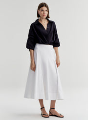 woman in white skirt and navy blue shirt