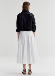 woman wearing navy blue button up shirt and white skirt