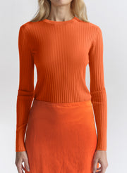 woman wearing orange top and matching midi skirt