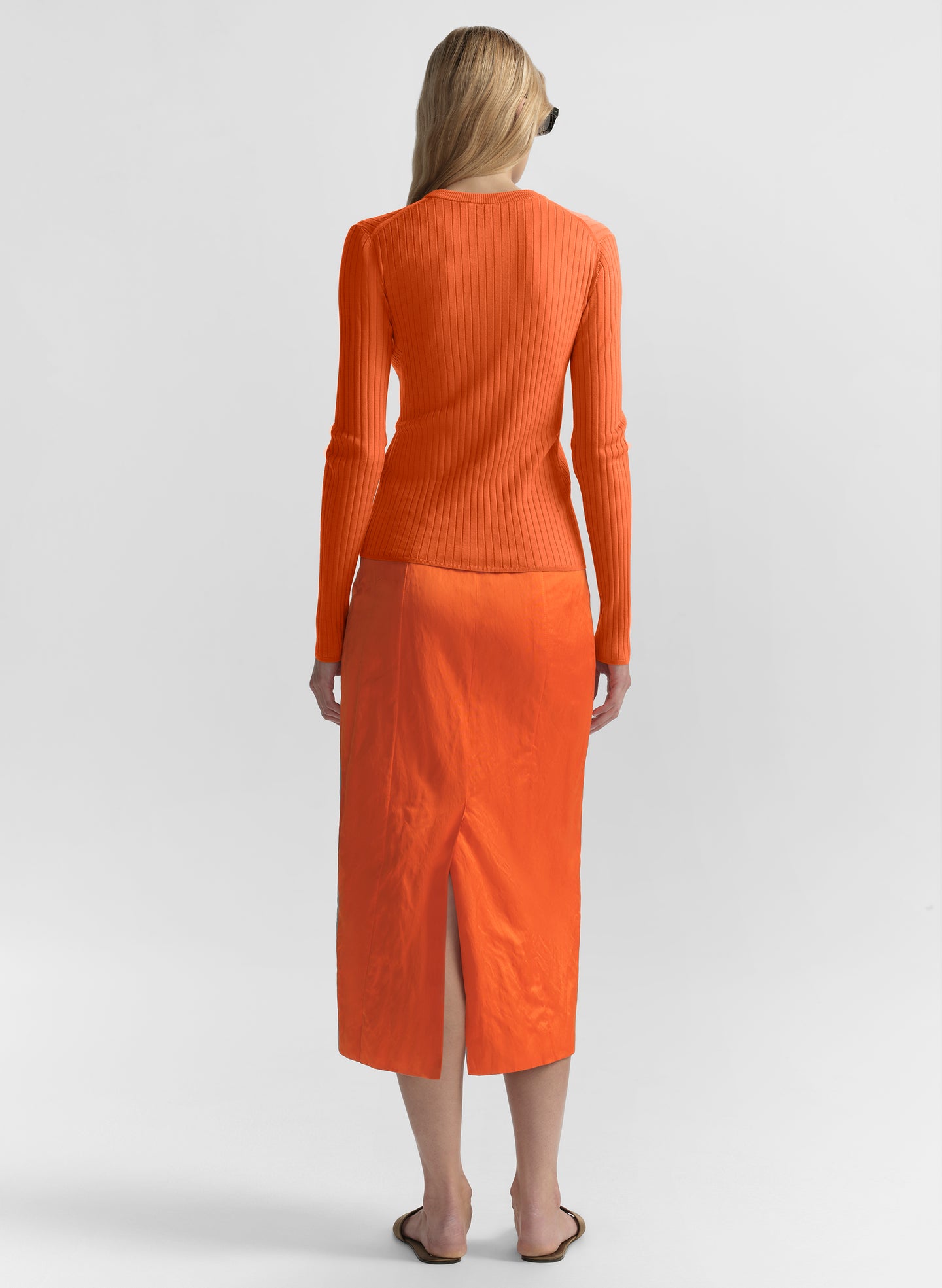woman wearing orange top and matching midi skirt
