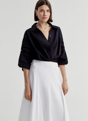 woman wearing navy blue shirt and white skirt