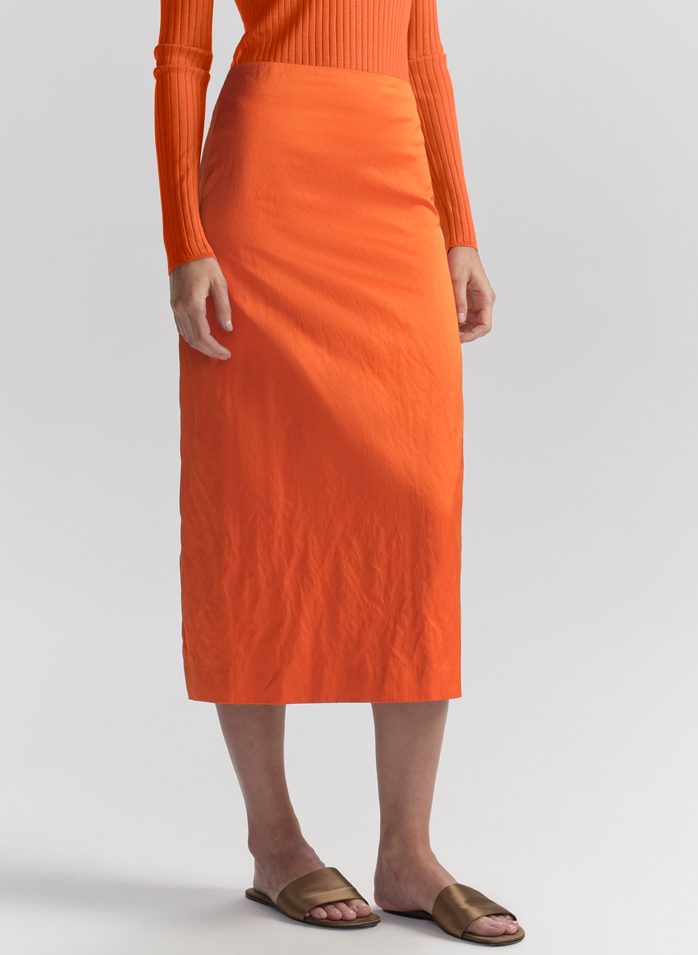 woman wearing orange top and orange midi skirt