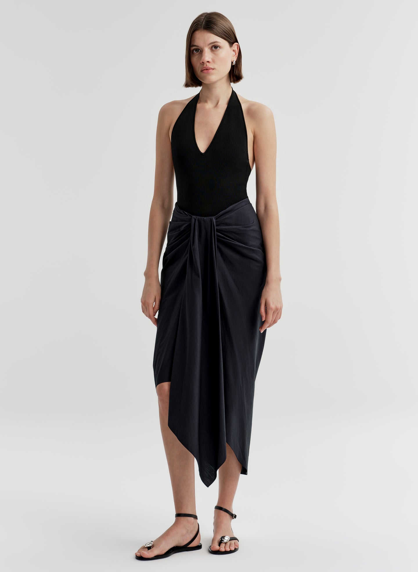 woman wearing black bodysuit and navy blue midi skirt