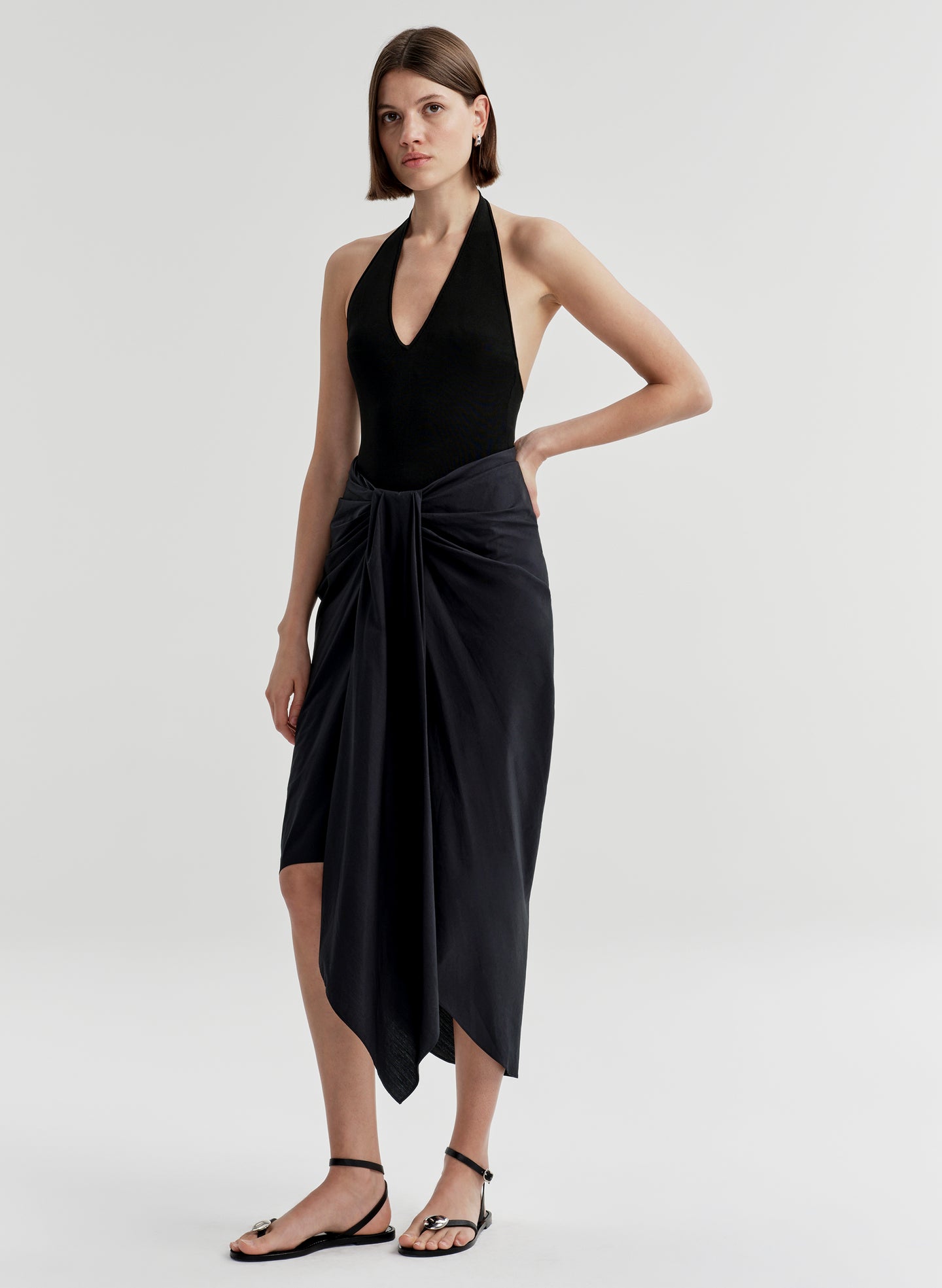 woman wearing black bodysuit and navy blue midi skirt