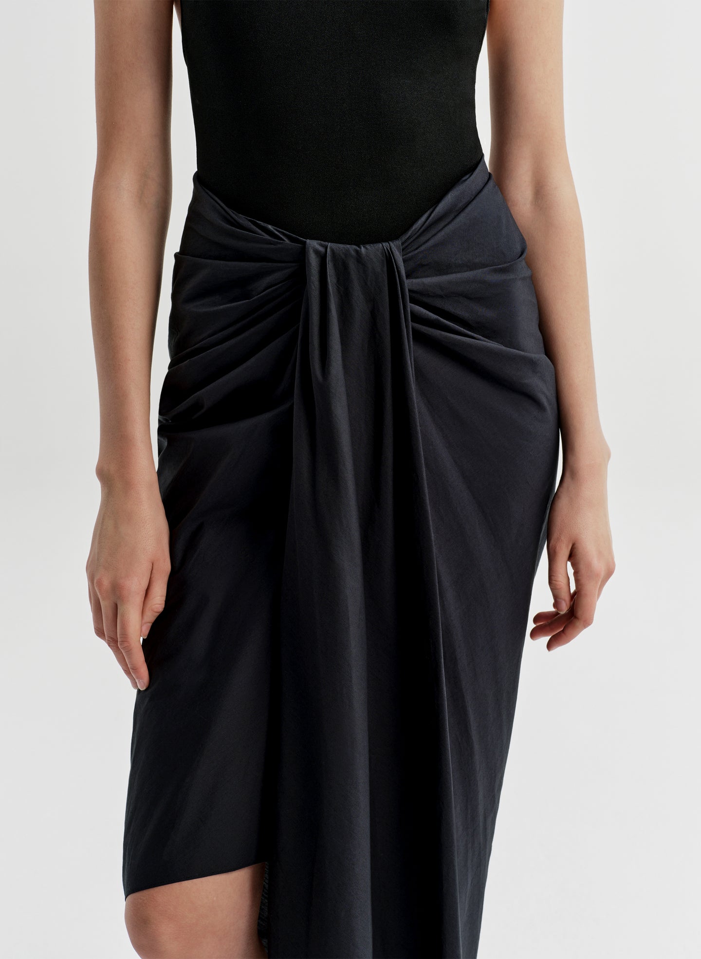 woman wearing black bodysuit and navy blue midi skirt