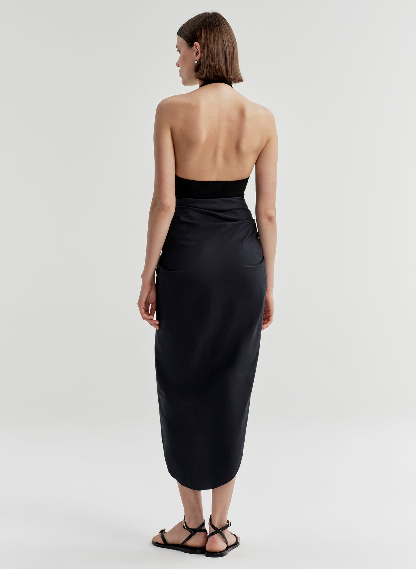 woman wearing black bodysuit and navy blue midi skirt