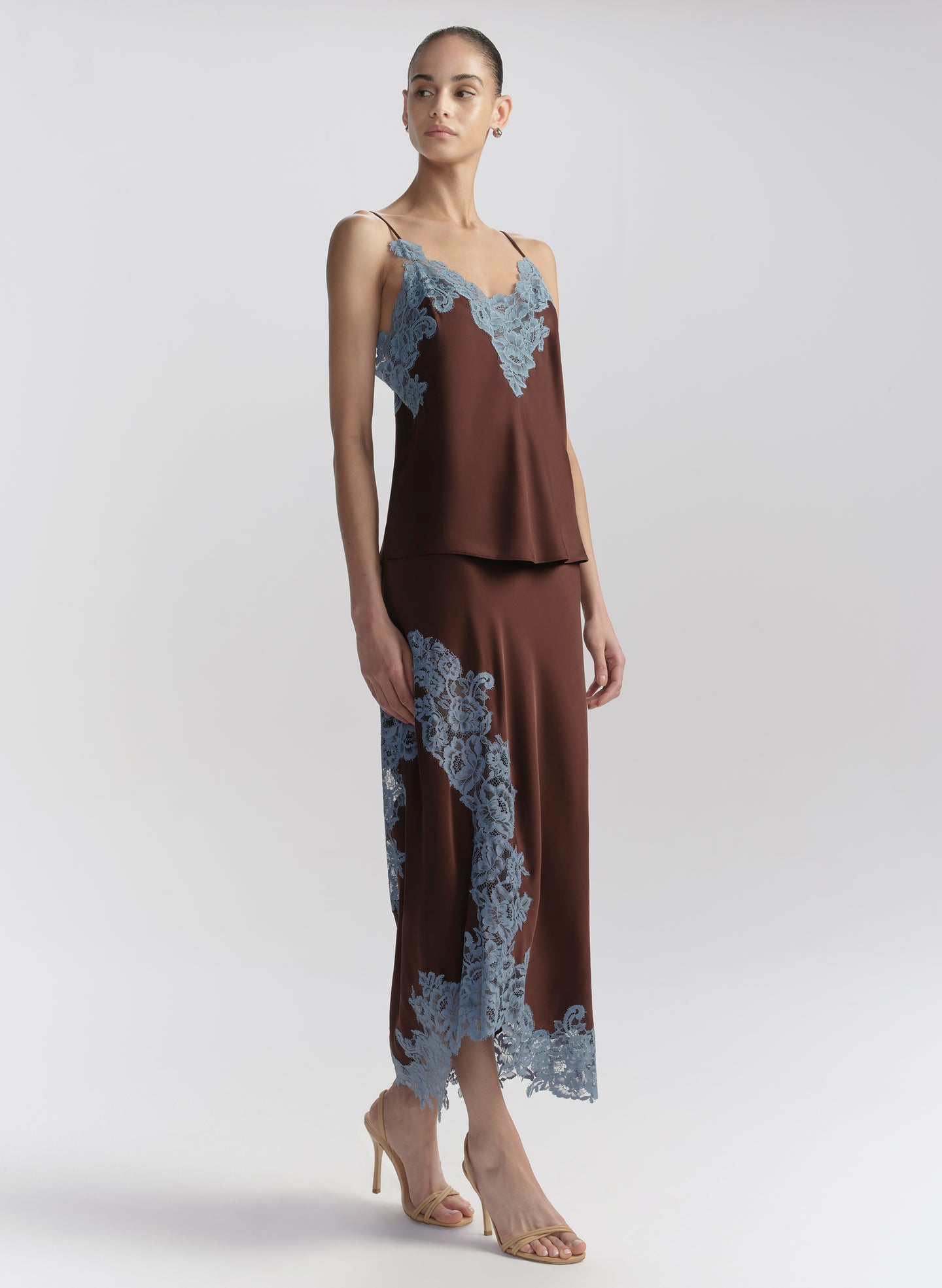 woman wearing brown camisole with blue lace trim and matching skirt