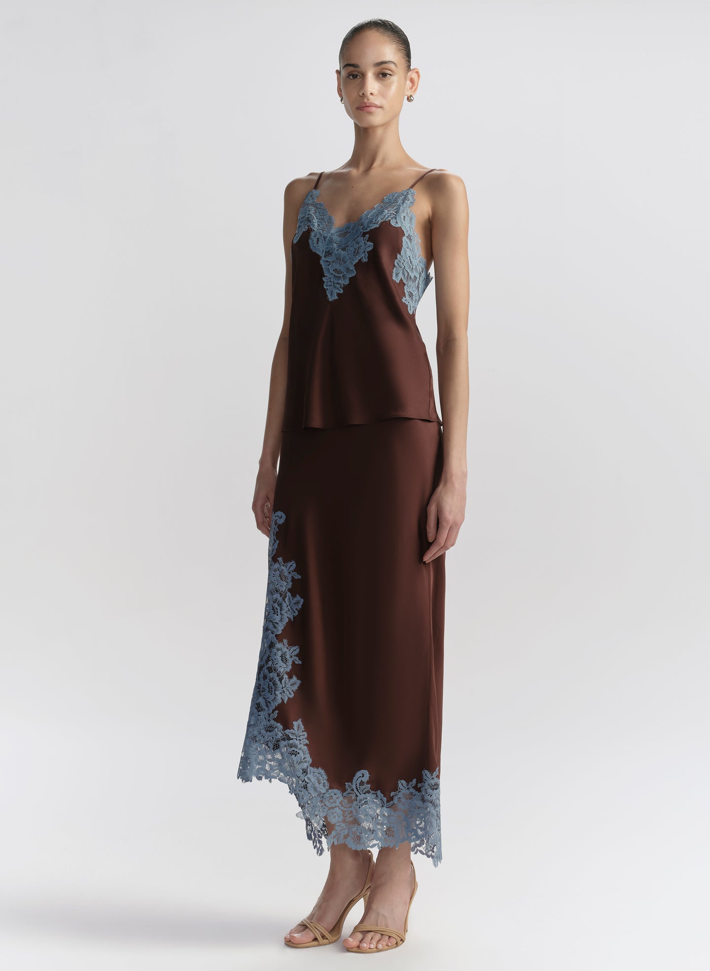 woman wearing brown camisole with blue lace trim and matching skirt