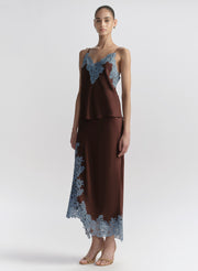 woman wearing brown camisole with blue lace trim and matching skirt