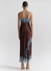 woman wearing brown camisole with blue lace trim and matching skirt