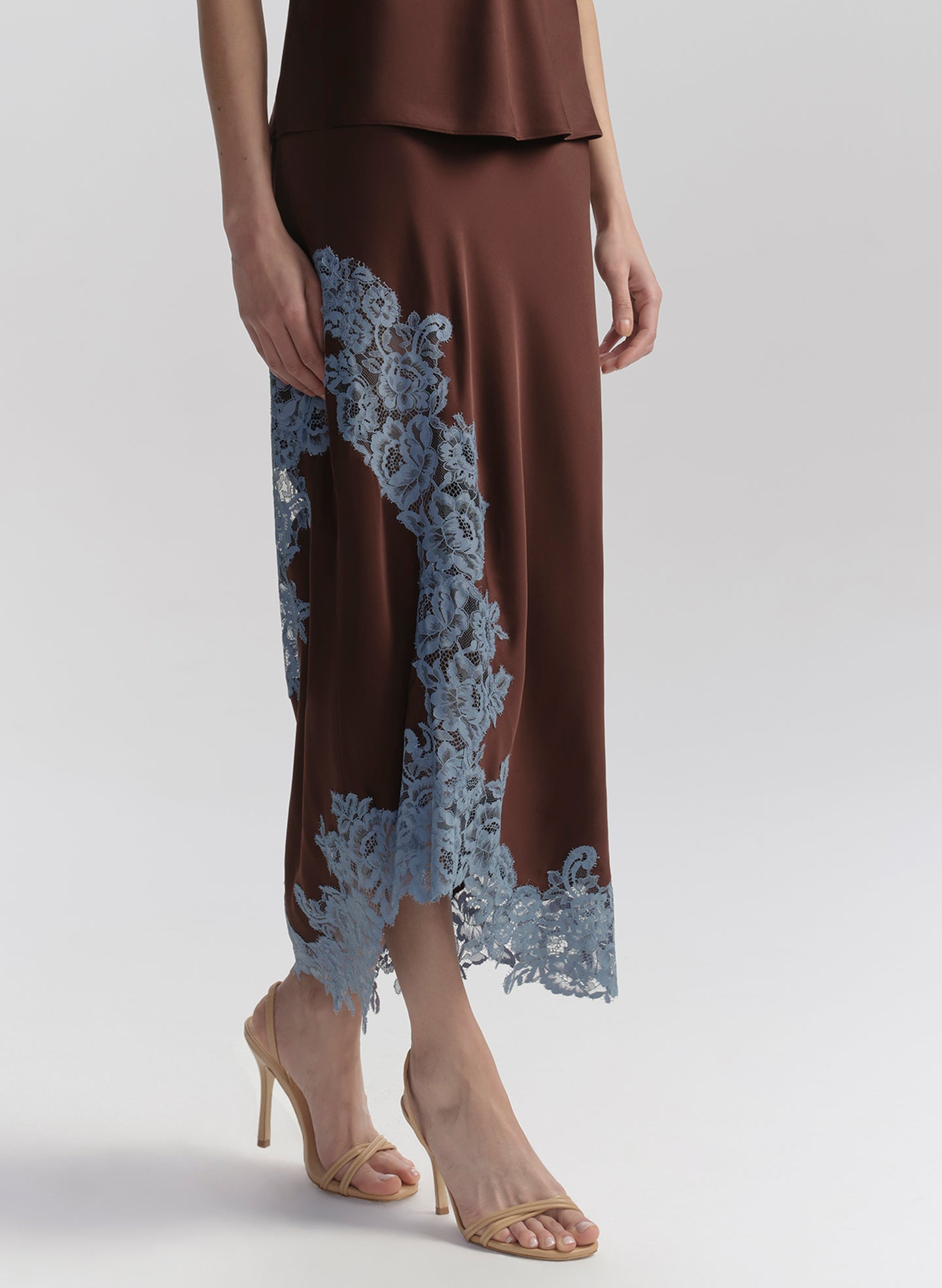 woman wearing brown camisole top with light blue lace and matching skirt