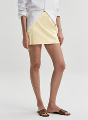 woman wearing white shirt and yellow satin mini skirt