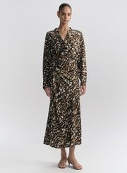 woman wearing brown patterned top and matching midi skirt