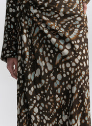 woman wearing brown patterned top and matching midi skirt