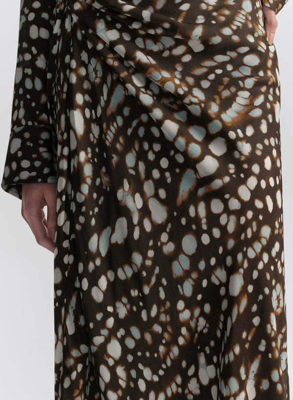 woman wearing brown patterned top and matching midi skirt