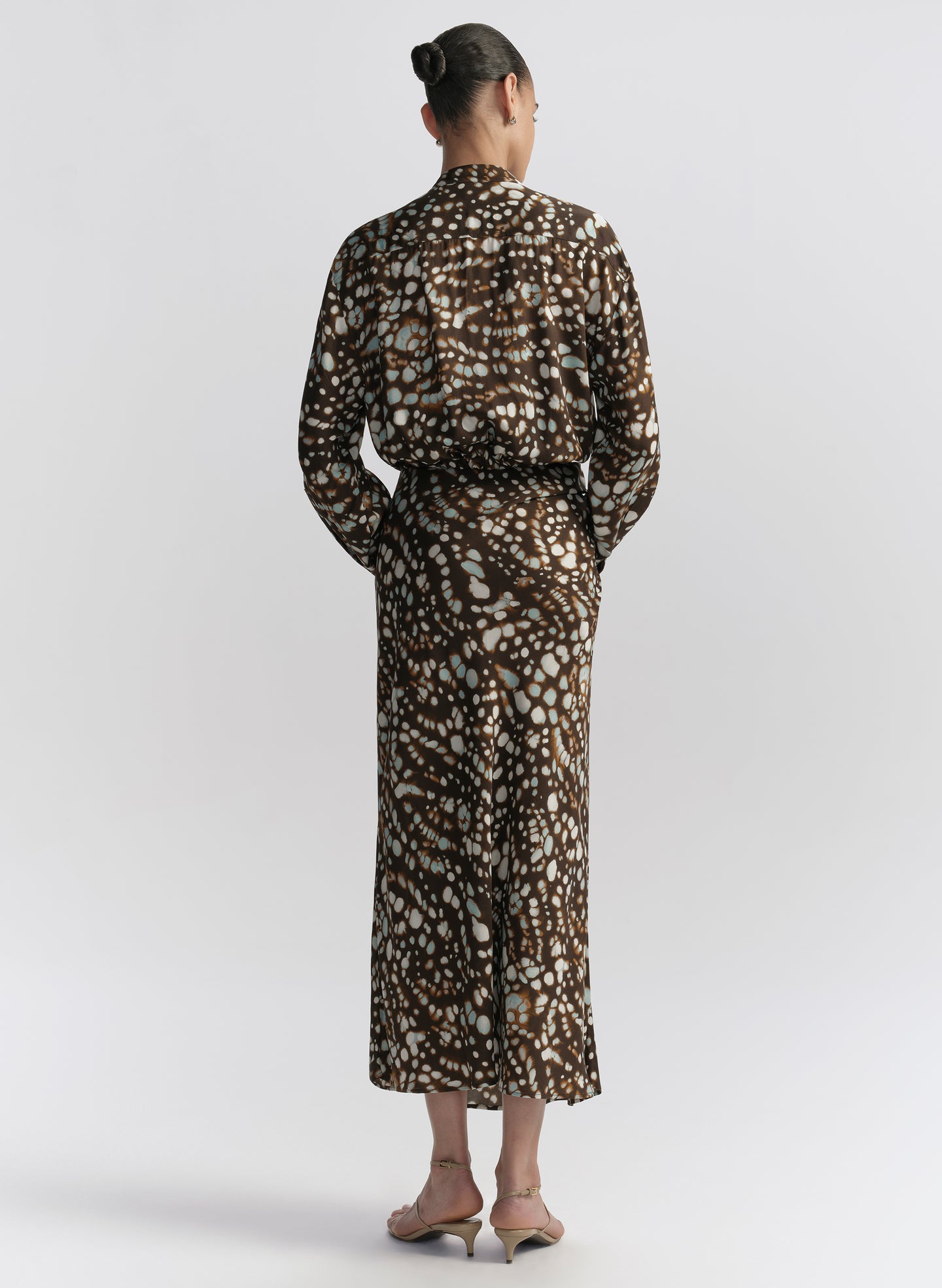 woman wearing brown patterned top and matching midi skirt