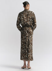 woman wearing brown patterned top and matching midi skirt