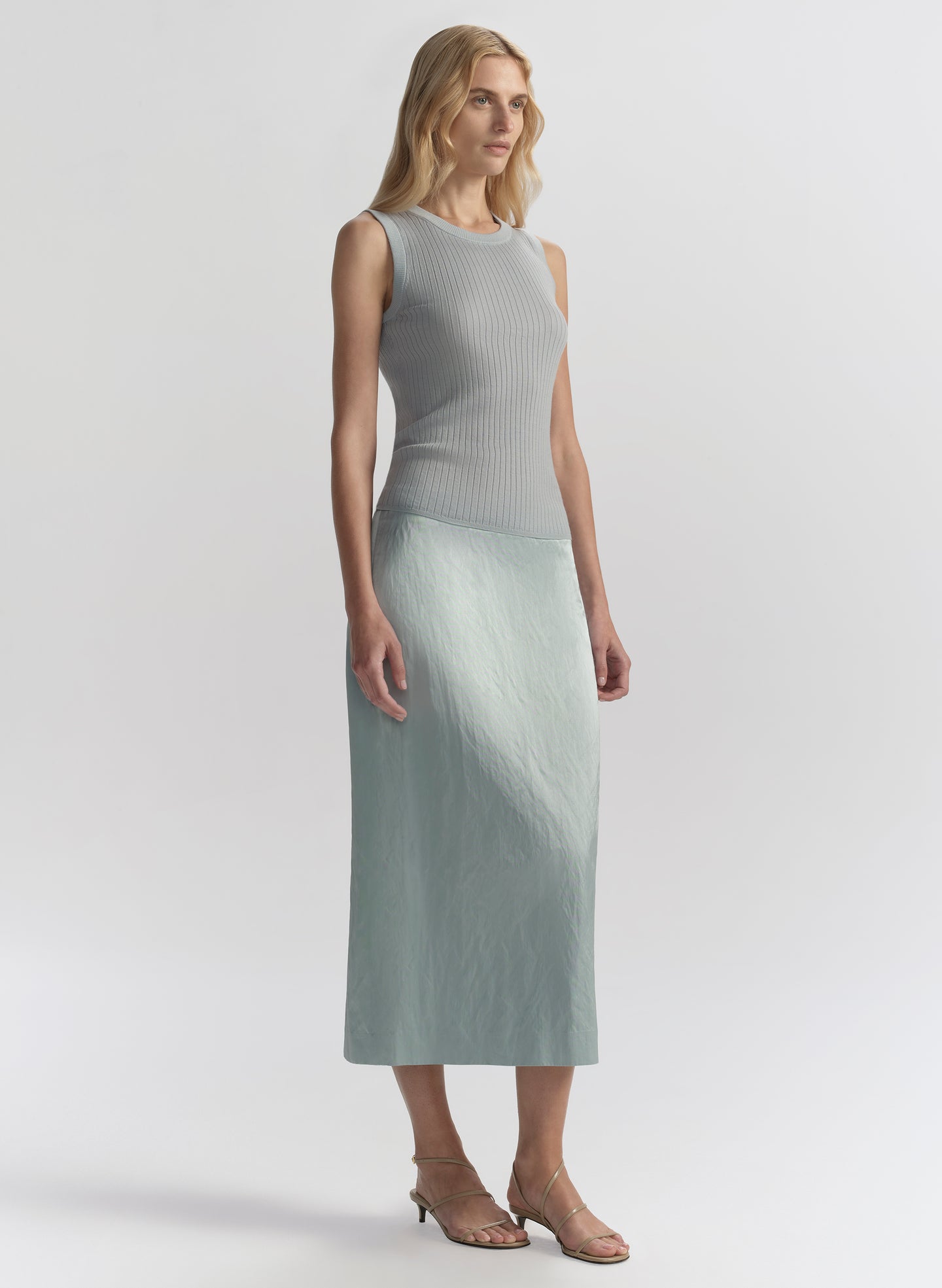 woman wearing light blue sleeveless top and matching midi skirt