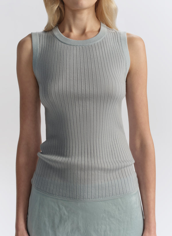 woman wearing light blue sleeveless top and matching midi skirt