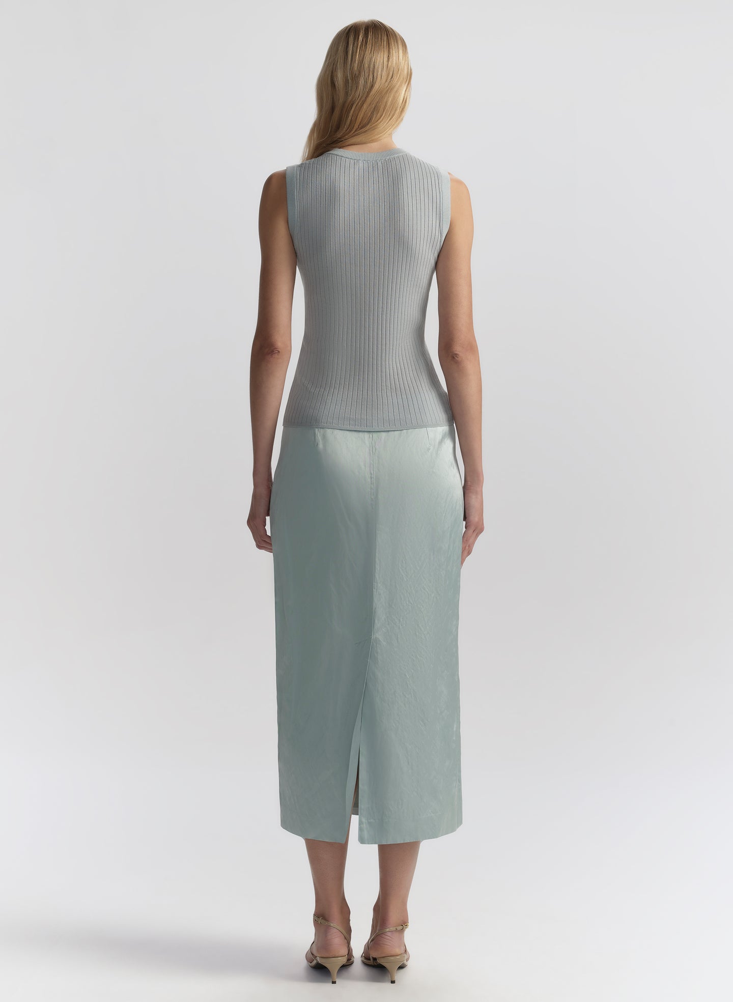 woman wearing light blue sleeveless top and matching midi skirt