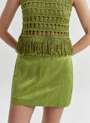 Green crochet top and skirt set on a plain background