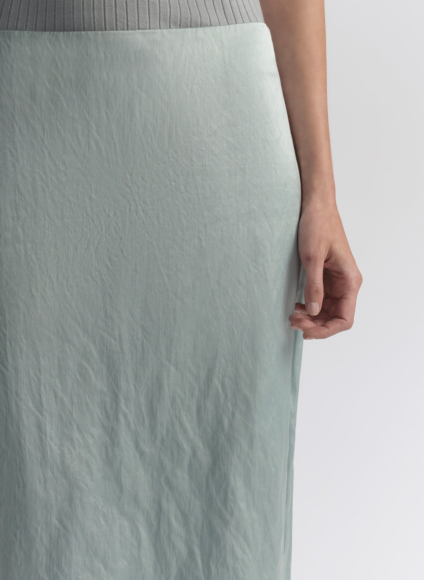 woman wearing light blue sleeveless top and matching midi skirt