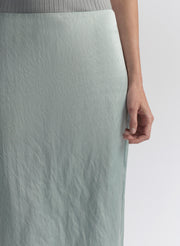 woman wearing light blue sleeveless top and matching midi skirt