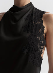 Black sleeveless top with lace detailing on a plain background