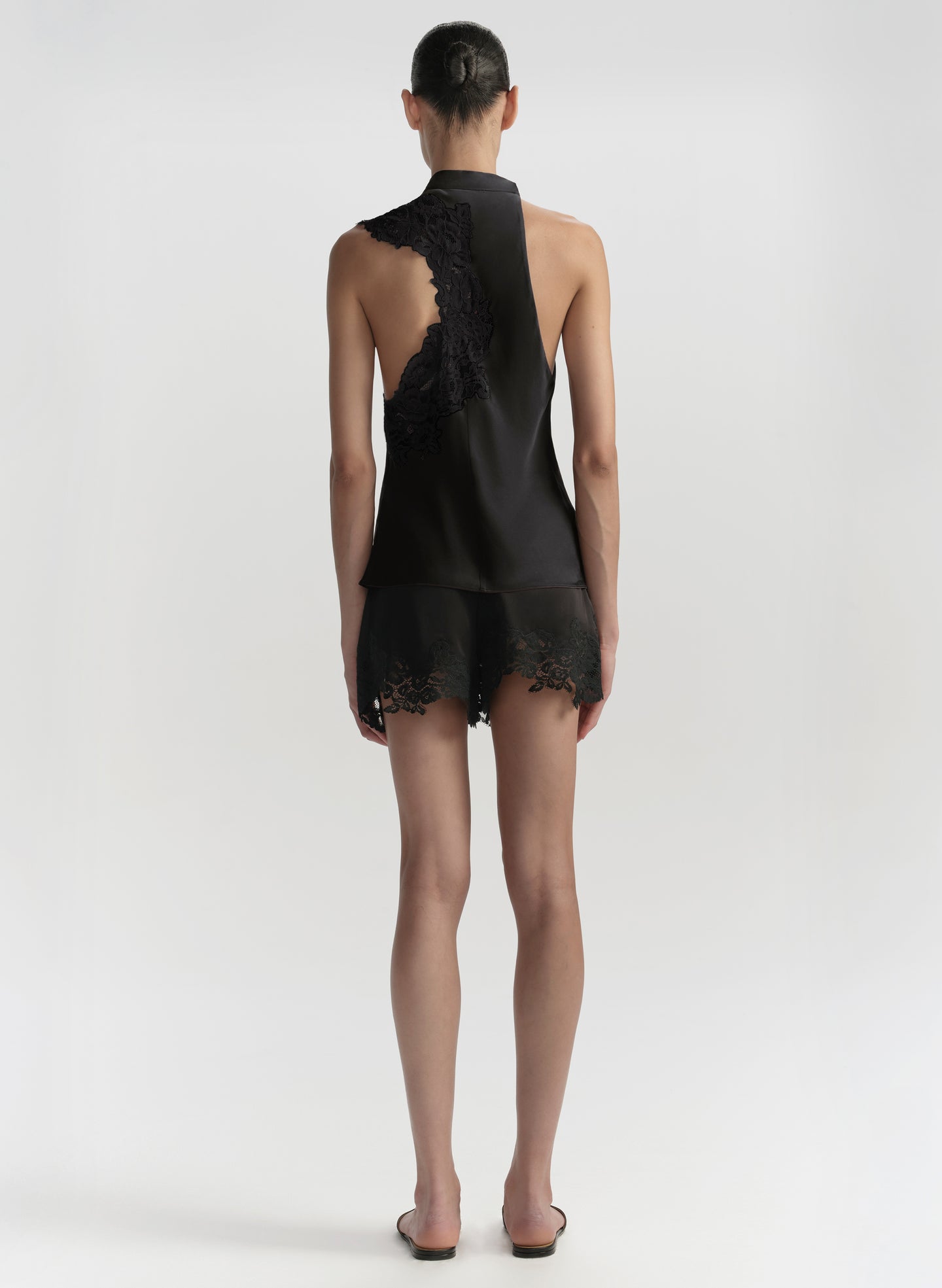 Black lace outfit worn by a model on a white background