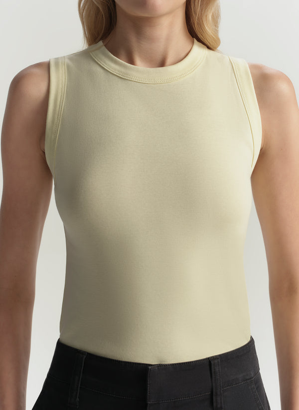 Yellow sleeveless top worn by a person on a plain background