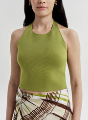 Woman wearing a green halter top and plaid skirt on a light gray background