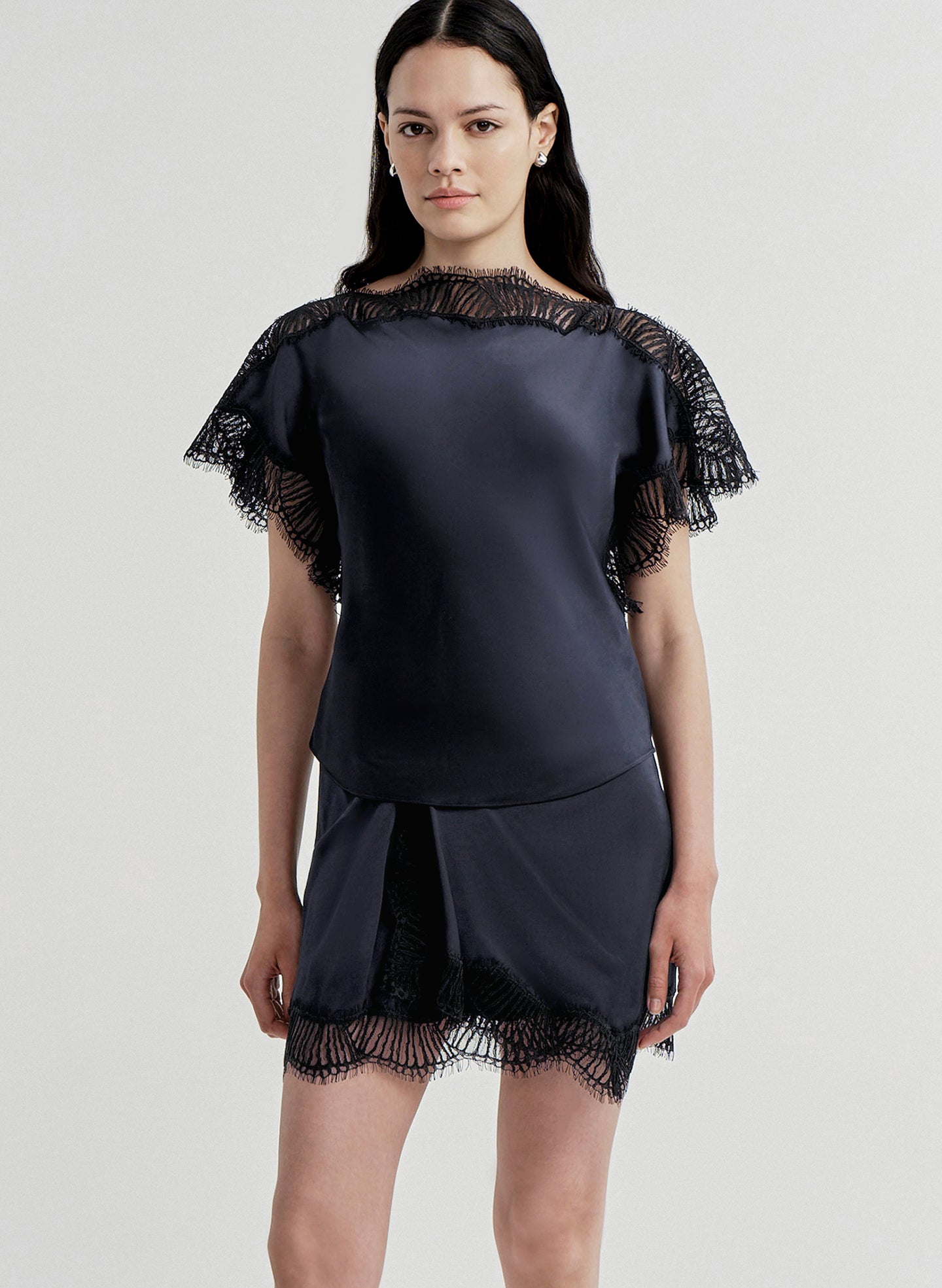 woman wearing blue satin and lace top with matching mini skirt