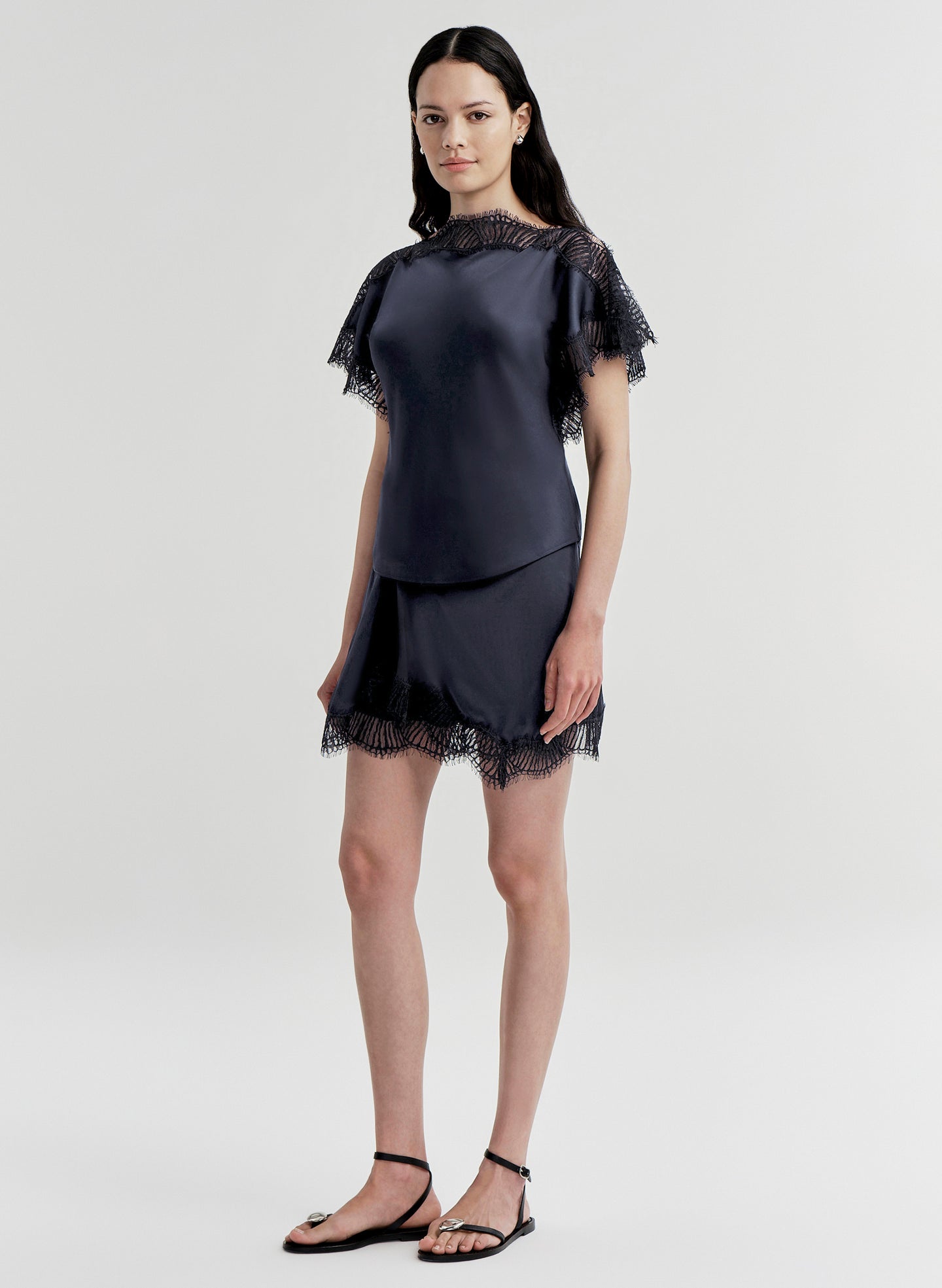 woman wearing blue satin and lace top with matching mini skirt