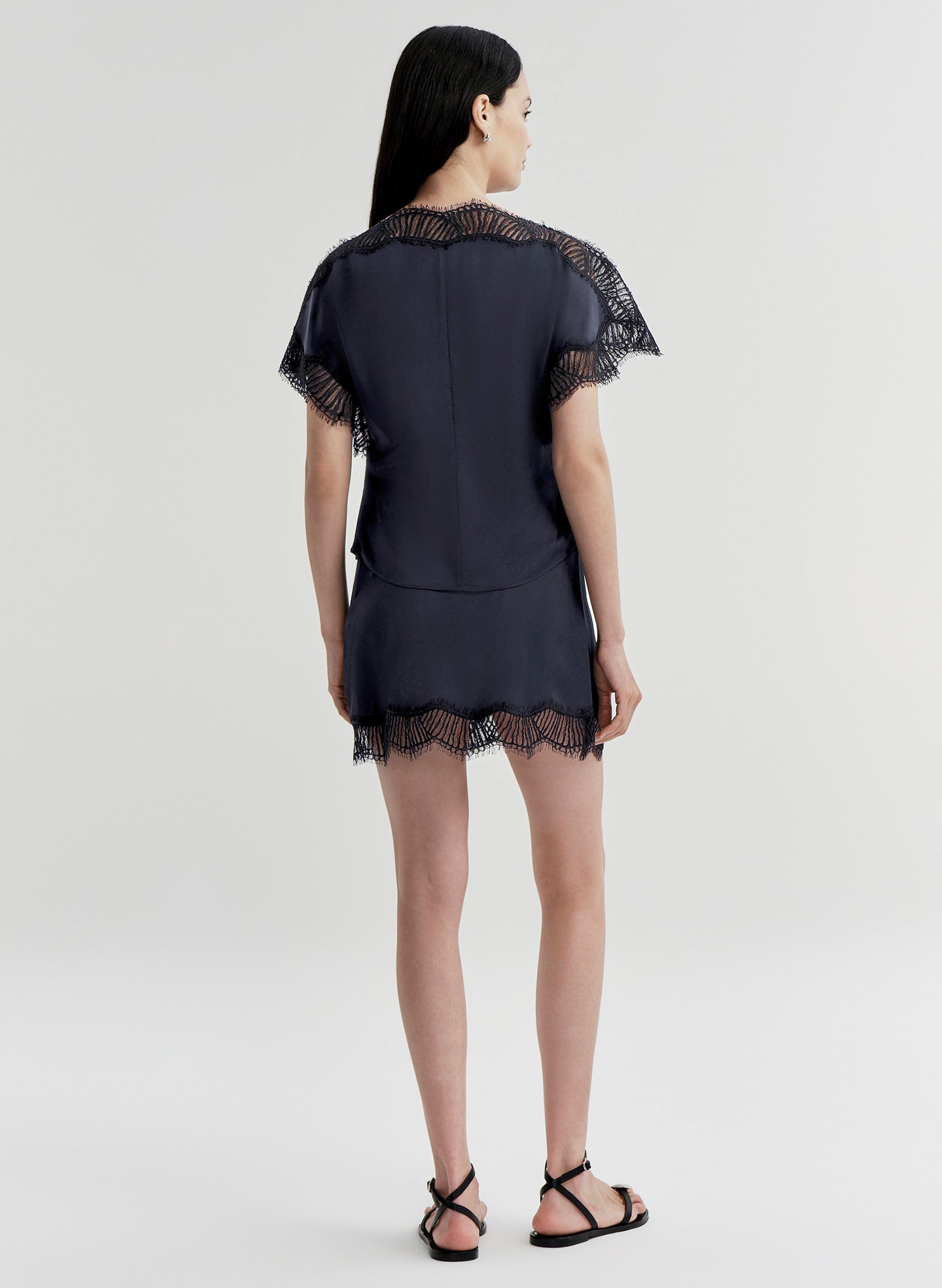 woman wearing blue satin and lace top with matching mini skirt