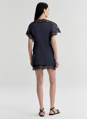 woman wearing blue satin and lace top with matching mini skirt
