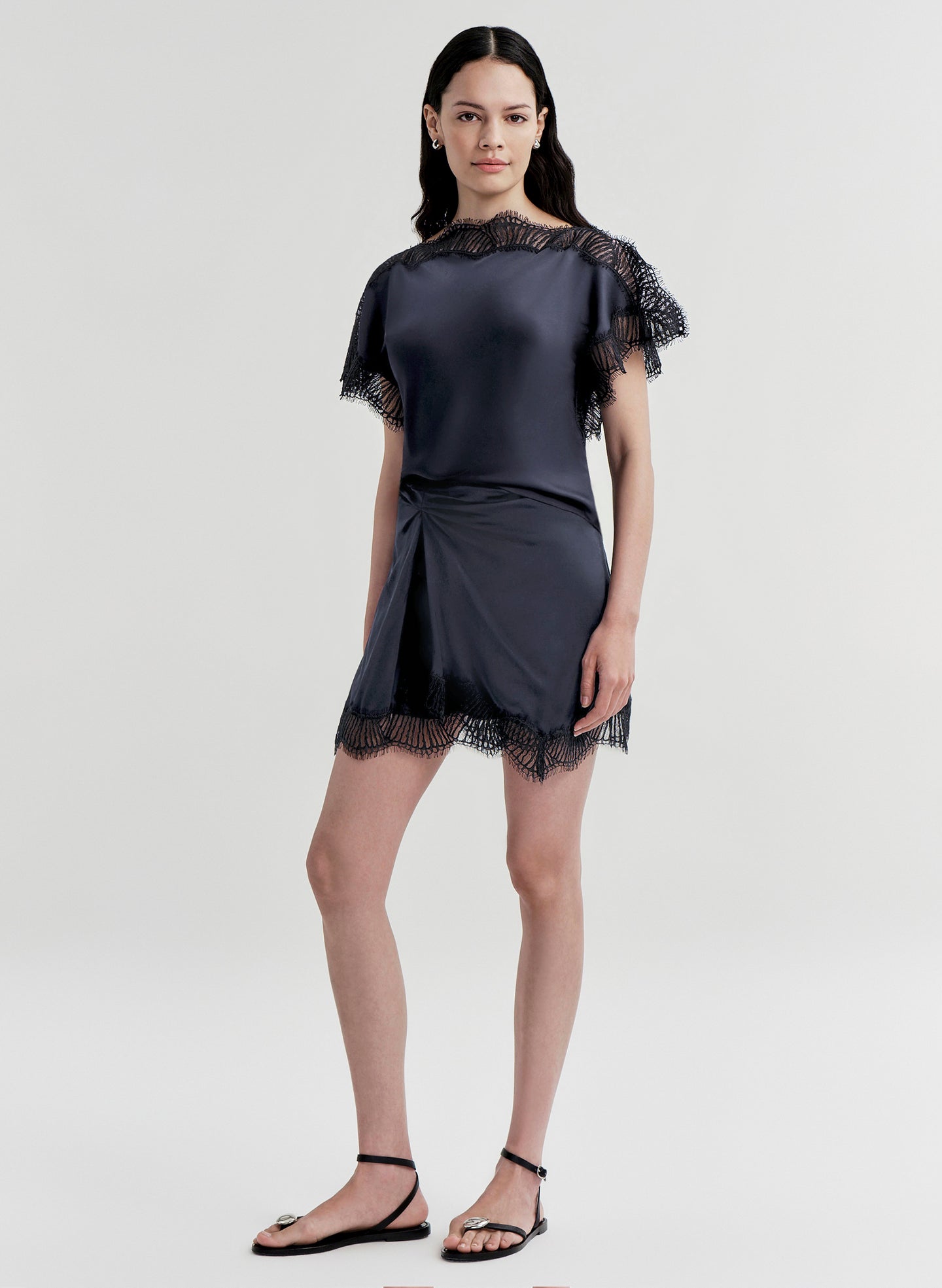 woman wearing blue satin and lace top with matching mini skirt